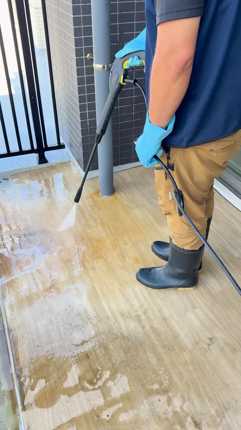バルコニーの床を高圧洗浄するTKCスタッフ